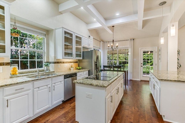 kitchen featuring dark wood finished floors, coffered ceiling, stainless steel appliances, backsplash, and a sink