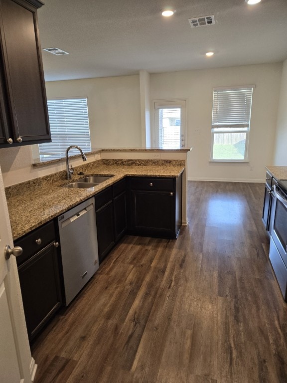 1337 Violet Ln, Kyle, TX 78640 - kitchen with a sink, visible vents, stainless steel appliances, light stone countertops, and dark wood finished floors