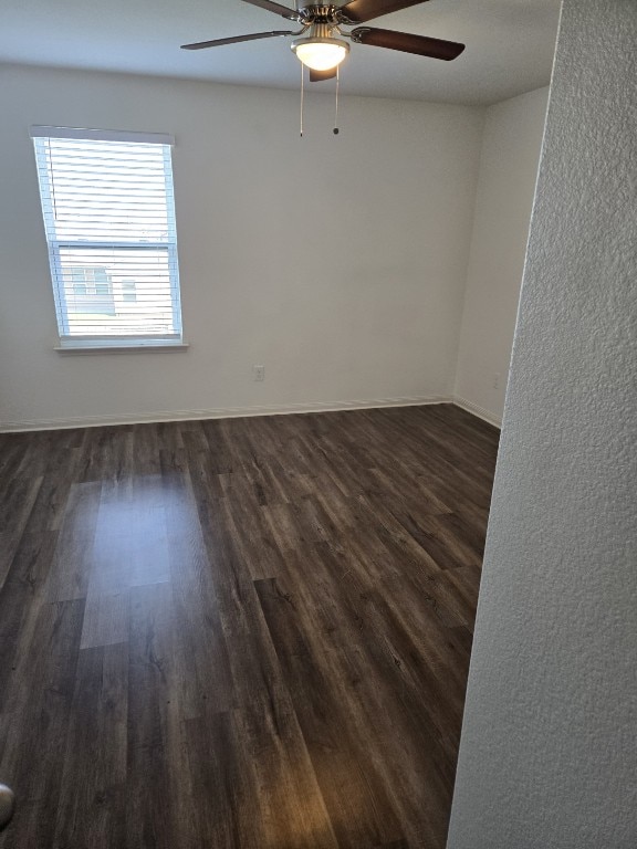 1337 Violet Ln, Kyle, TX 78640 - unfurnished room with dark wood-style floors, baseboards, and a ceiling fan