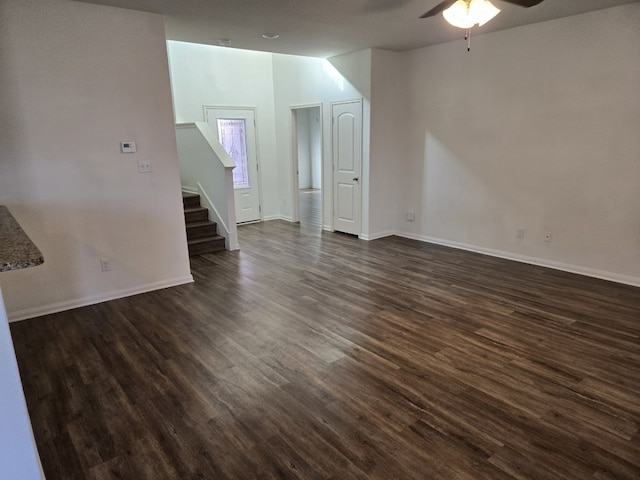 1337 Violet Ln, Kyle, TX 78640 - unfurnished living room featuring ceiling fan, dark wood-style floors, stairs, and baseboards