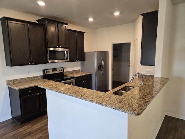 1337 Violet Ln, Kyle, TX 78640 - kitchen featuring stainless steel appliances, a sink, dark wood-style floors, light stone counters, and baseboards