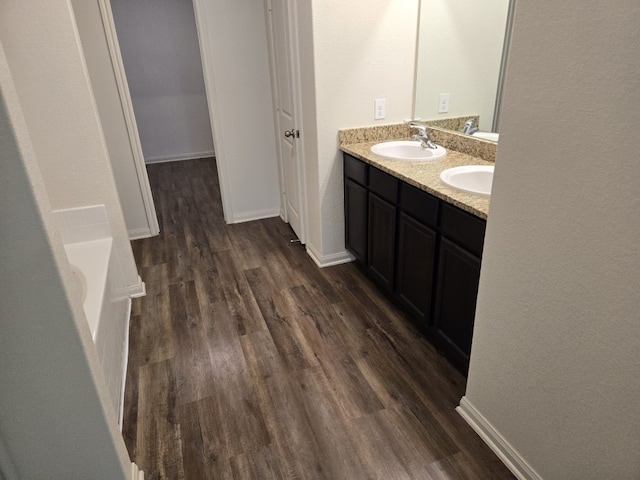 1337 Violet Ln, Kyle, TX 78640 - full bath with a sink, a bathing tub, double vanity, baseboards, and wood finished floors