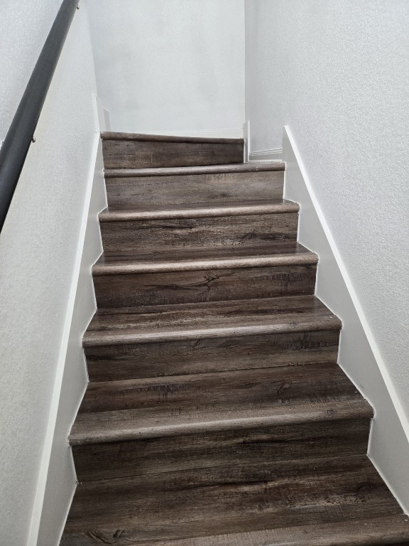 1337 Violet Ln, Kyle, TX 78640 - stairway featuring wood finished floors and a textured wall