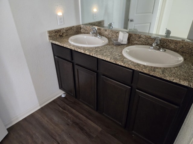 1337 Violet Ln, Kyle, TX 78640 - bathroom with double vanity, wood finished floors, baseboards, and a sink