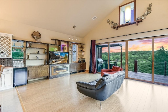 611 N Cuernavaca Dr Unit 301, Austin, TX 78733 - living room featuring high vaulted ceiling, light wood-style floors, beverage cooler, and a glass covered fireplace