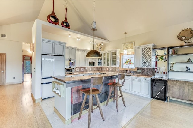 611 N Cuernavaca Dr Unit 301, Austin, TX 78733 - kitchen featuring tasteful backsplash, high vaulted ceiling, white refrigerator, a kitchen breakfast bar, and a center island