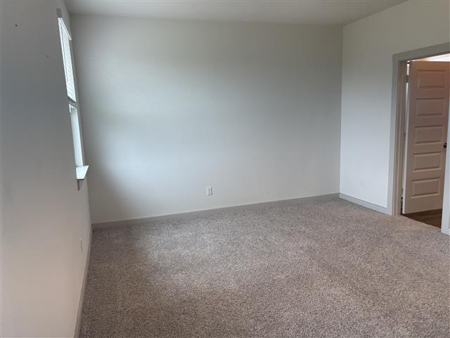 carpeted empty room with baseboards