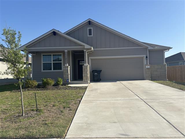 115 Big Cypress Bayou Rd, Hutto, TX 78634 - craftsman inspired home with a garage, stone siding, driveway, and board and batten siding