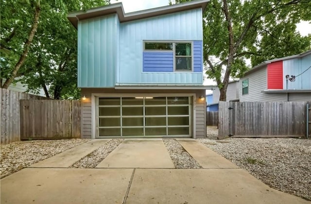 view of front of home featuring fence, concrete driveway, and an attached garage