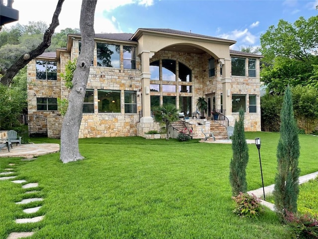 3113 Ski Shores Ter, Austin, TX 78730 - back of house featuring a balcony, stone siding, a lawn, and a patio