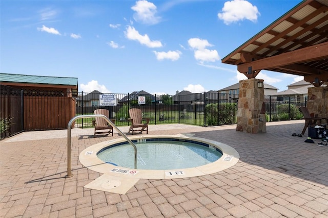 view of pool featuring fence, a community hot tub, a residential view, and a patio area