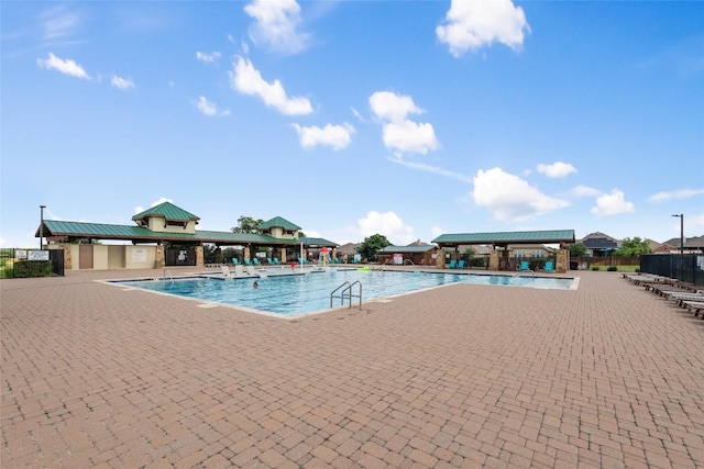 community pool featuring fence, a gazebo, and a patio area