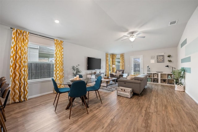 living room with wood finished floors, visible vents, and a ceiling fan