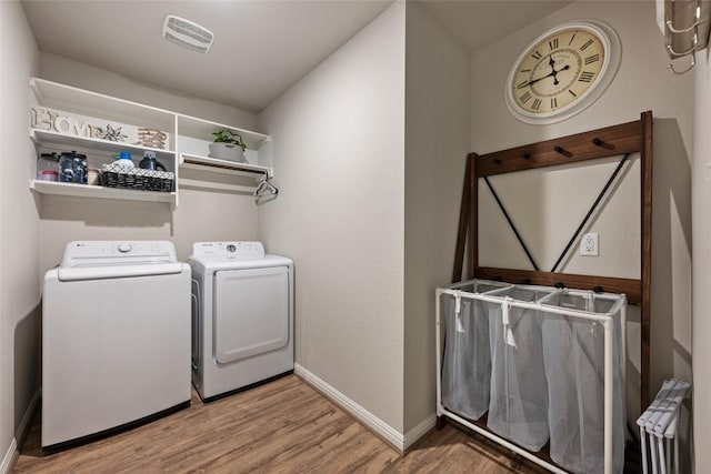 laundry room with visible vents, baseboards, light wood-type flooring, separate washer and dryer, and laundry area