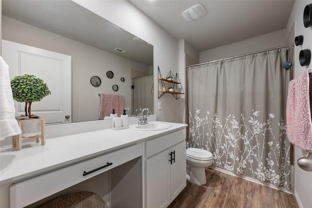 full bath with toilet, vanity, visible vents, and wood finished floors