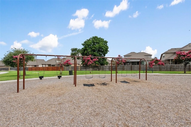 community jungle gym with fence and a yard