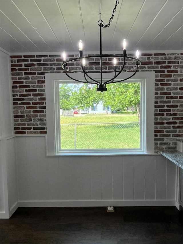 5611 Joe Sayers Ave, Austin, TX 78756 - unfurnished dining area featuring healthy amount of natural light, dark wood finished floors, and brick wall
