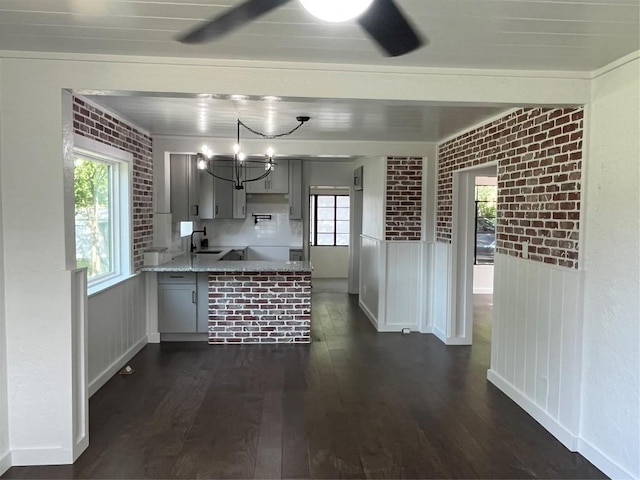 5611 Joe Sayers Ave, Austin, TX 78756 - kitchen with a peninsula, dark wood-style floors, plenty of natural light, a sink, and brick wall