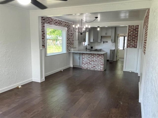 5611 Joe Sayers Ave, Austin, TX 78756 - kitchen featuring a peninsula, gray cabinetry, plenty of natural light, dark wood-style floors, and a textured wall