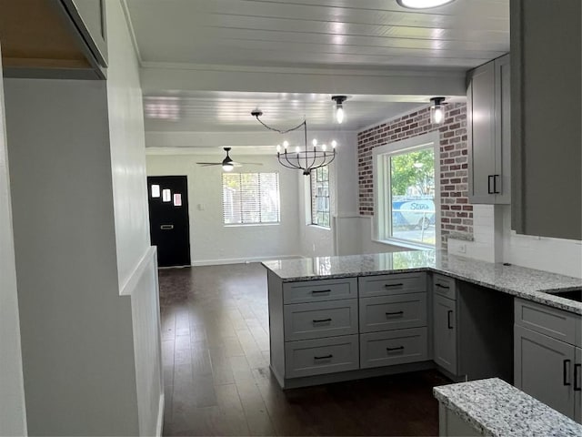 5611 Joe Sayers Ave, Austin, TX 78756 - kitchen featuring a peninsula, light stone countertops, a chandelier, and dark wood finished floors