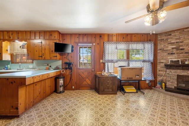 3602 Ferguson Ln, Austin, TX 78754 - kitchen featuring ceiling fan, brown cabinets, light countertops, light floors, and wooden walls