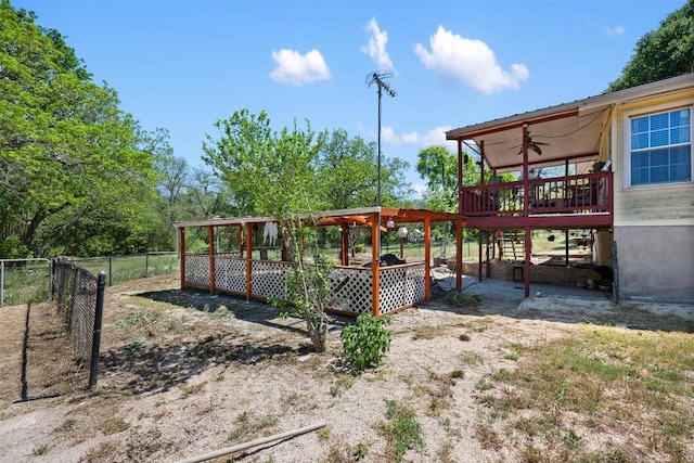 view of yard featuring a ceiling fan, a wooden deck, and fence