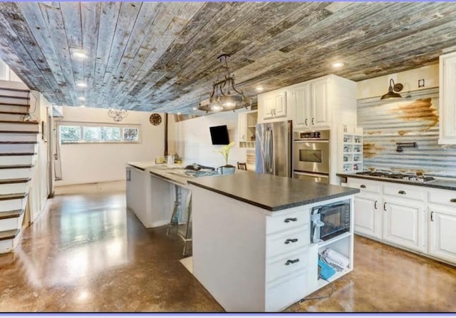 kitchen with white cabinetry, dark countertops, appliances with stainless steel finishes, and wood ceiling