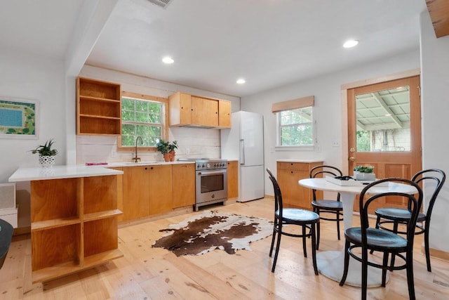 1405 Cometa St, Austin, TX 78721 - kitchen with stainless steel range, open shelves, freestanding refrigerator, light wood-type flooring, and light countertops