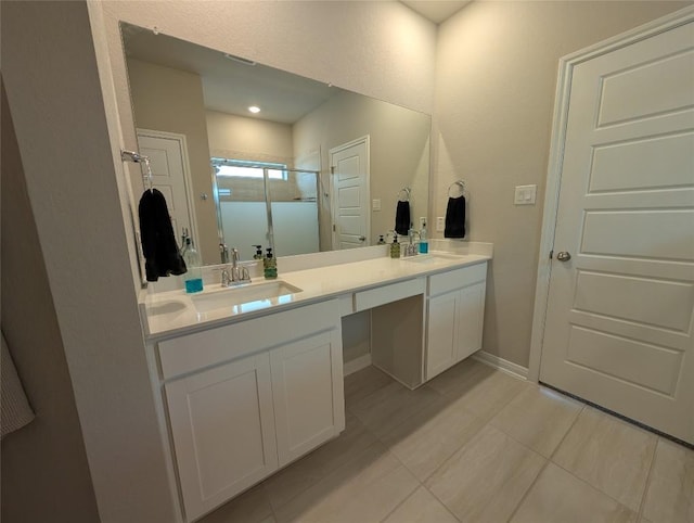 bathroom featuring a stall shower, tile patterned flooring, double vanity, and a sink