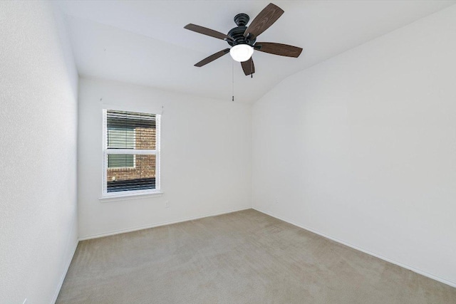 spare room with baseboards, a ceiling fan, lofted ceiling, and light carpet