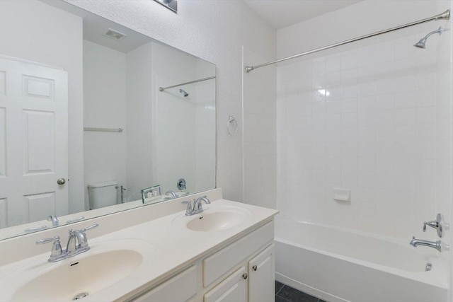 full bathroom with double vanity, visible vents, washtub / shower combination, and a sink