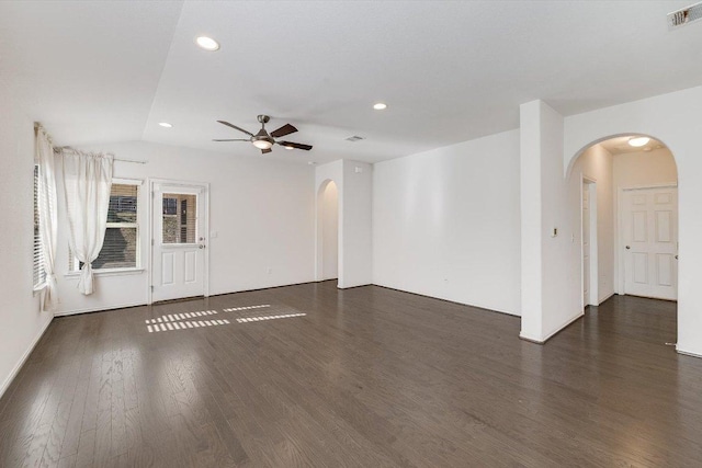spare room with visible vents, arched walkways, ceiling fan, and wood finished floors