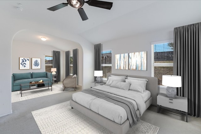 carpeted bedroom with arched walkways, ceiling fan, and vaulted ceiling