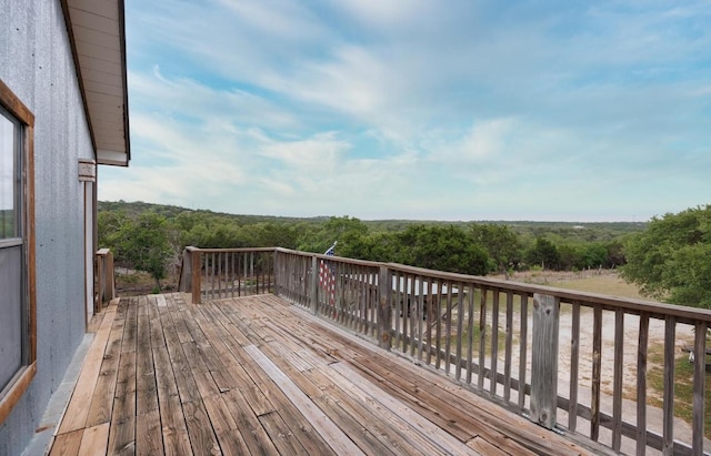 wooden terrace featuring a wooded view