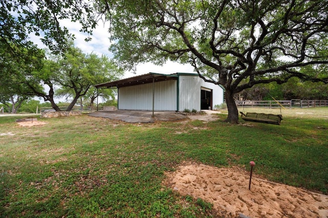 view of yard featuring an outbuilding, a detached garage, and fence