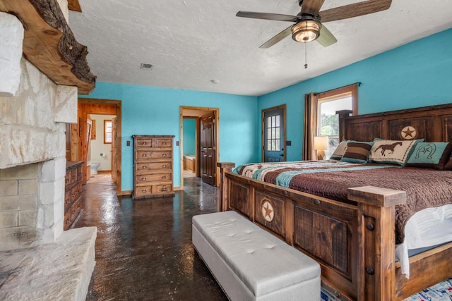bedroom with a textured ceiling, visible vents, concrete flooring, a ceiling fan, and ensuite bath