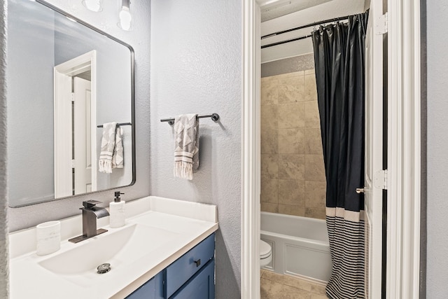 bathroom with a textured wall, toilet, shower / bath combination with curtain, tile patterned floors, and vanity