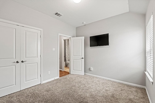 unfurnished bedroom featuring visible vents, carpet floors, and baseboards