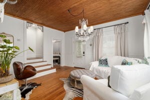 128 E Cedar St, La Grange, TX 78945 - living room featuring wood finished floors, a notable chandelier, a fireplace, and wood ceiling