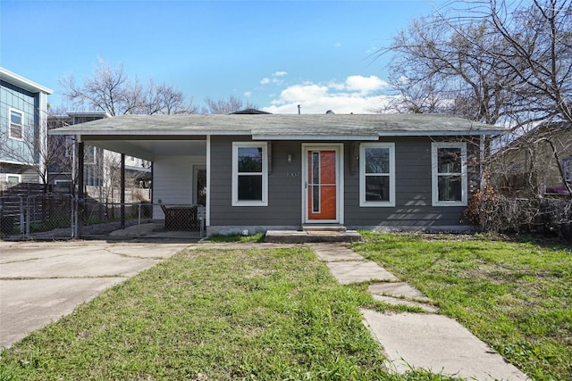 view of front of property with a front yard, driveway, an attached carport, and fence