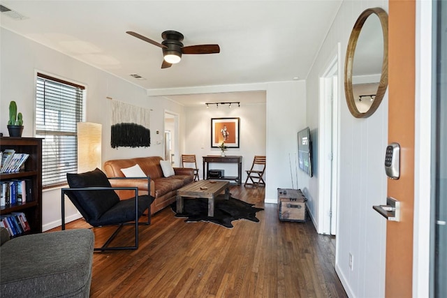 living room with visible vents, ceiling fan, rail lighting, and dark wood-type flooring