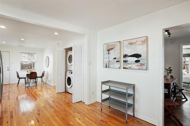 entryway featuring recessed lighting, stacked washer and clothes dryer, light wood-style flooring, and baseboards