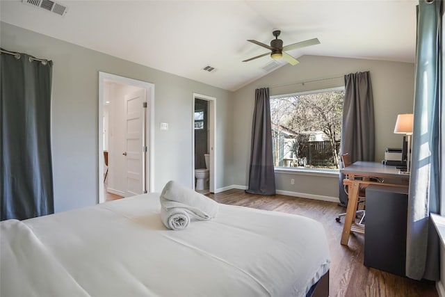 bedroom featuring lofted ceiling, visible vents, wood finished floors, and ensuite bath
