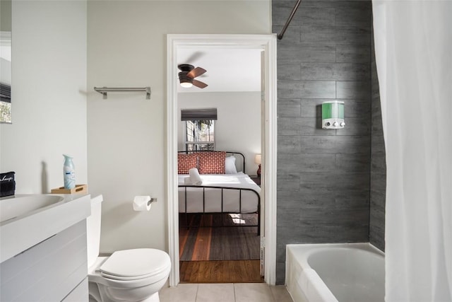 ensuite bathroom with ensuite bath, tile patterned floors, ceiling fan, toilet, and vanity