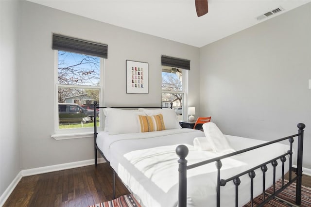 bedroom featuring wood-type flooring, visible vents, multiple windows, and baseboards