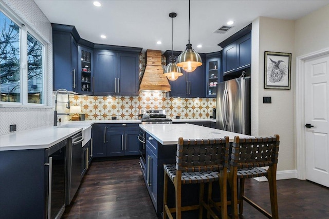 kitchen featuring dark wood-style floors, a center island, appliances with stainless steel finishes, and premium range hood