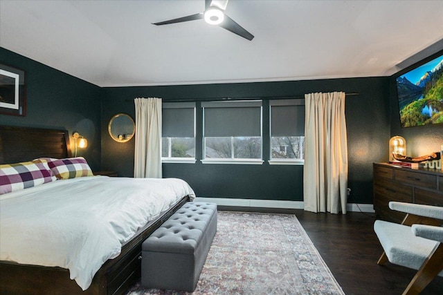 bedroom with a ceiling fan, multiple windows, vaulted ceiling, and wood finished floors