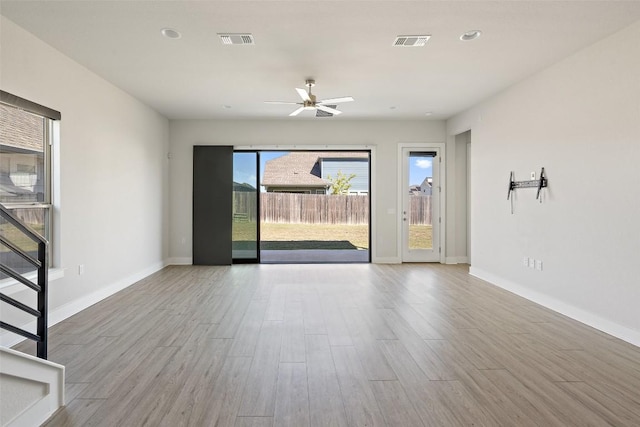 unfurnished living room featuring visible vents, ceiling fan, wood finished floors, and baseboards