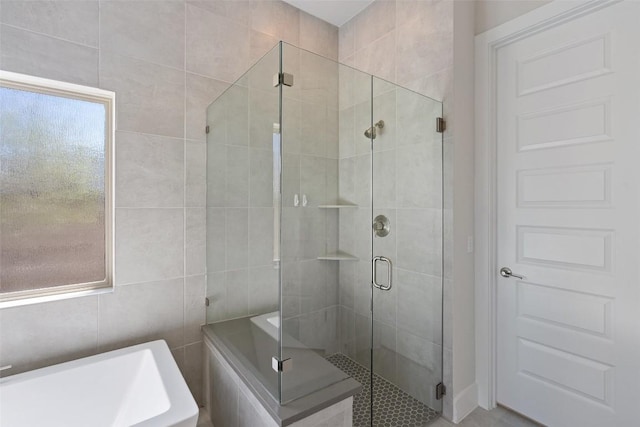 full bathroom with a stall shower, tile walls, and a tub