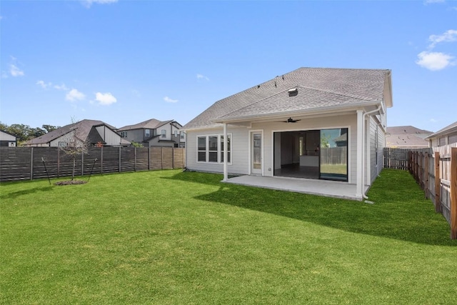 rear view of house featuring a yard, a shingled roof, a fenced backyard, and a patio area
